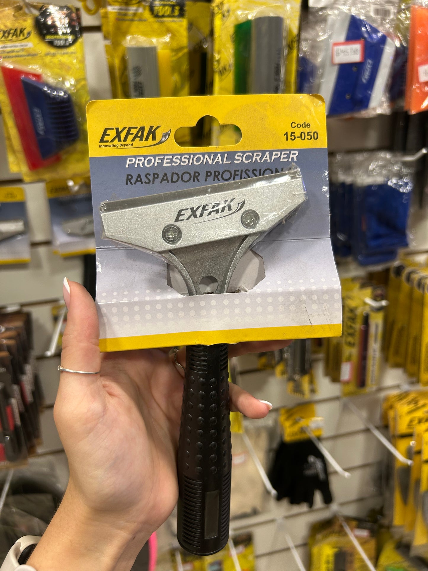 Raspador de vidro com cabo plástico.